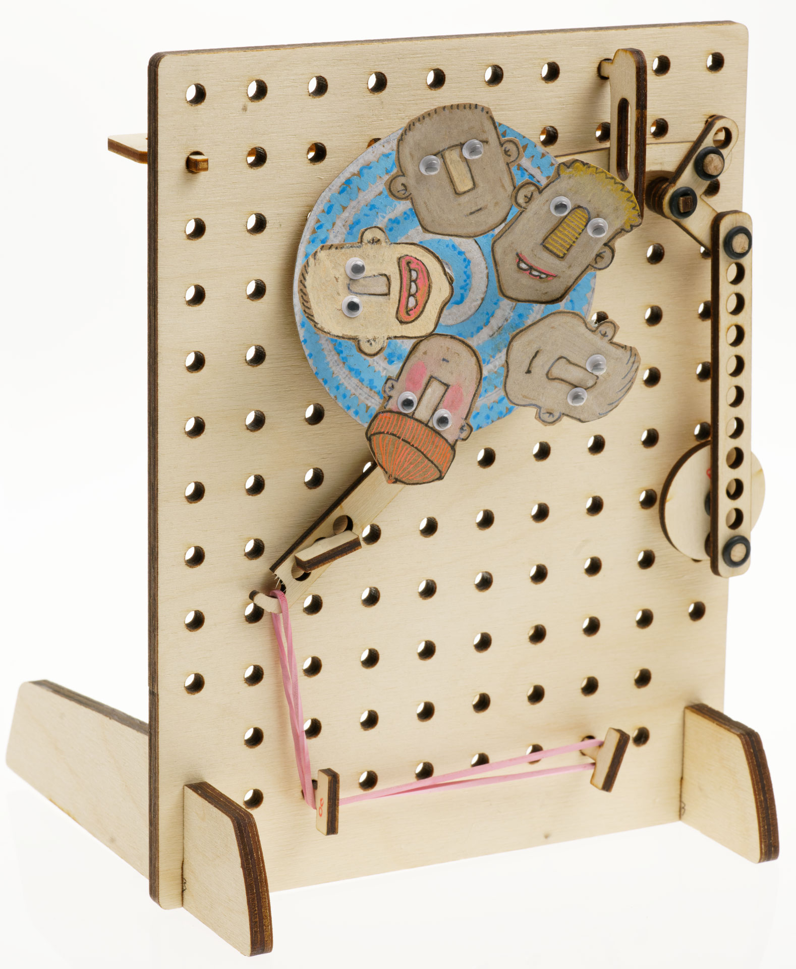 Wood pegboard with ratchet mechanism and a wheel with cartoon faces and google eyes