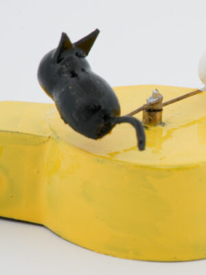 A miniature black cat chases a white mouse in a circle. Mounted on a yellow base with wire handle.