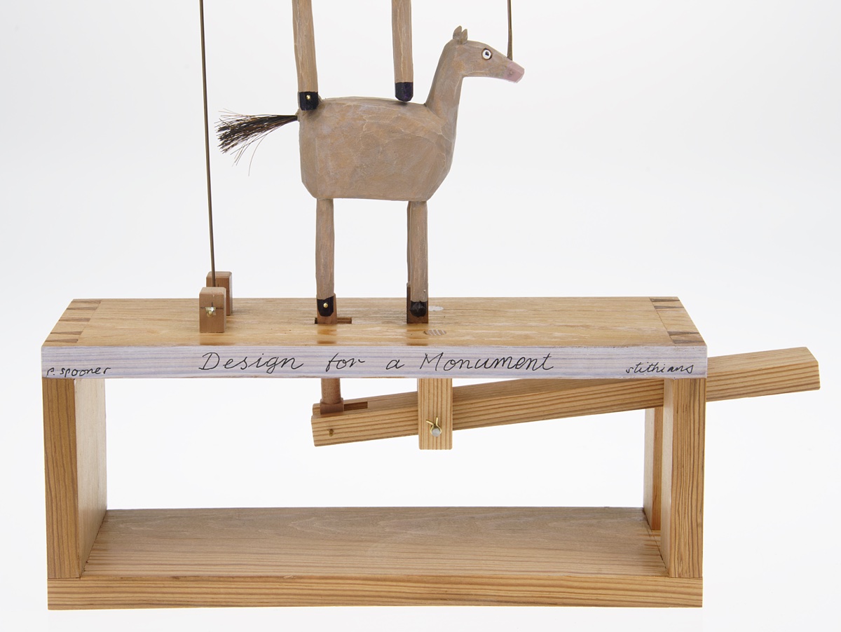 Carved wooden horse standing on an open box with a lever mechanism inside.
