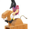 The Anubis is wearing a striped shirt and riding a camel. Carved wooden automata.