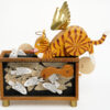 Wooden automata. A ginger cat with wings and halo sits atop a large fish tank.