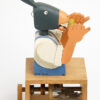 Carved painted wooden automata. A Donkey in blue dungarees and white shirt, eats a corn on the cob.