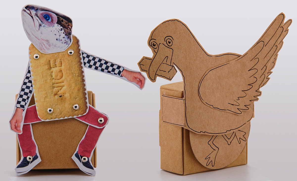 2 card automata, 1 hand drawn pseagull eating a chip on brown card and 1 collage character made with a biscuit body and fish head.