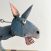 Close up of Donkey's face. He has a beady eye and pink inner ear.