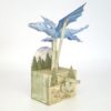 Card automata kit. A blue dragon flies over trees, moved by a crank.
