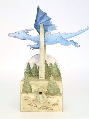 Card automata kit. A blue dragon flies over trees, moved by a crank.