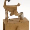 A wooden goat with one leg in a white metal bucket