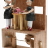 2 scary dolls slicing meat in front of a wall with a window