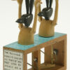 Wood automata - 2 carved Anubis hold a canoe above their heads. Only their top halves are visible above the water.