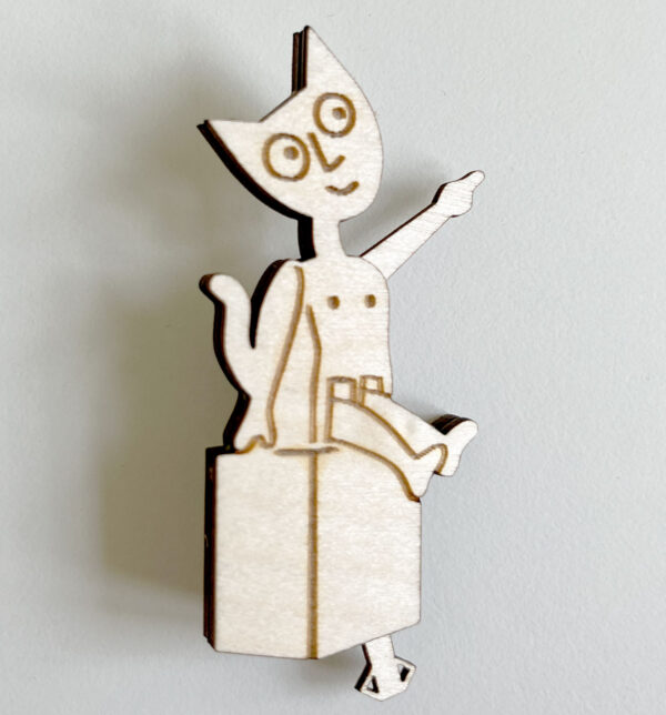 A small barecat made of laser cut and engraved birch ply. He is smiling and pointing up.