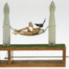 Anubis reclines in a hammock between two asparagus spears