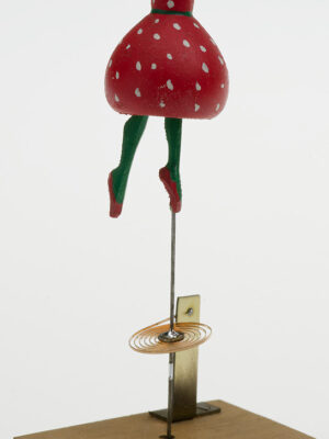 Strawberry Fool- Anubis in a Red spotty dress with green tights balances on a wobbly spring.