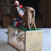 Brightly painted wooden automata. The ring master leans towards the lion.